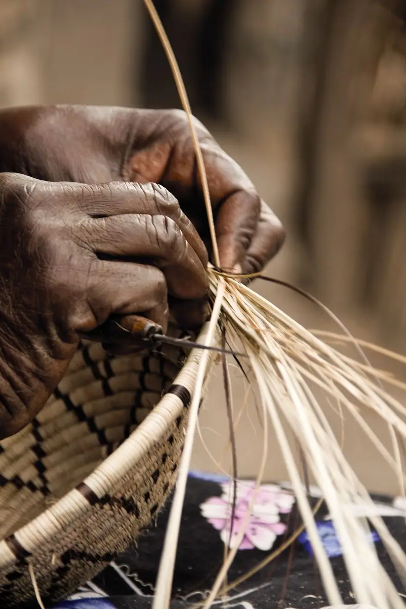 Elder hands weaving a small basket